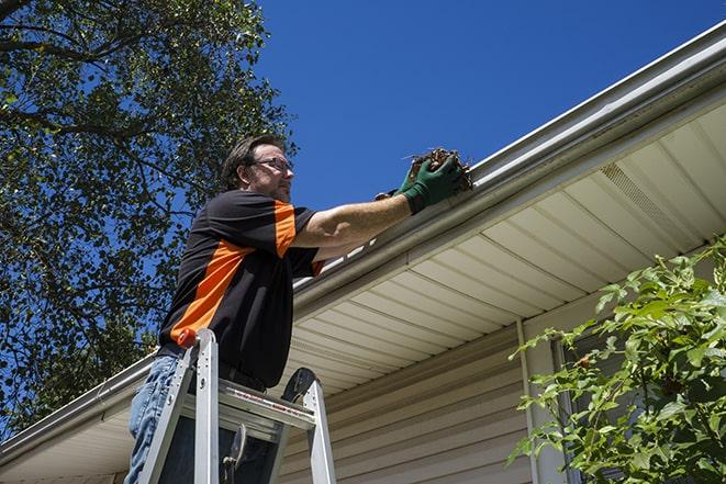 gutter repair specialist at work fixing a broken rain gutter in Elkmont AL